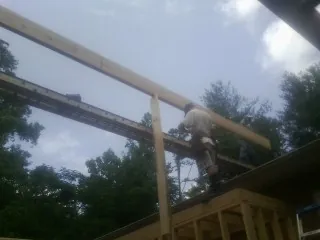 Carpenter setting a ridge beam over a new addition frame — Ice Dam Removal by Roofing Brothers in North Sandwich