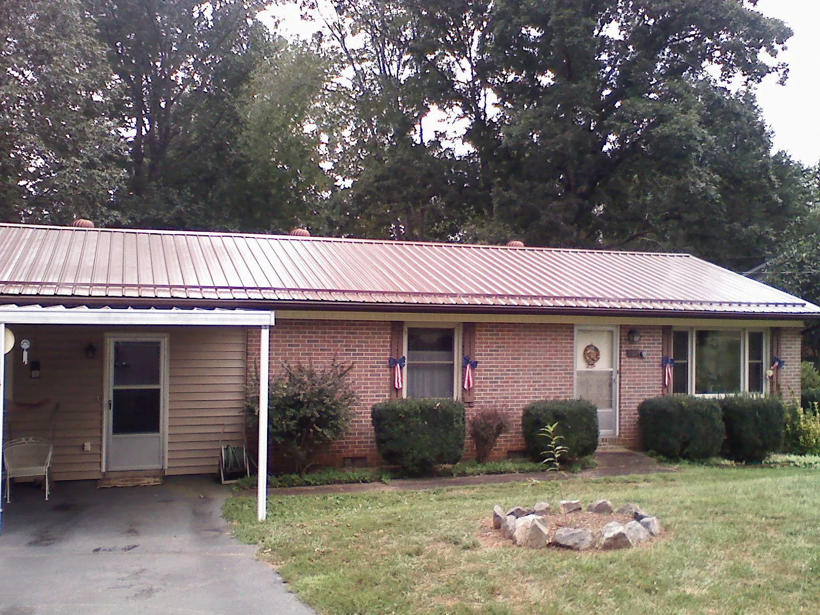 Bronze metal roof and carport on a brick ranch home — Roof Repair work by our crew in North Sandwich